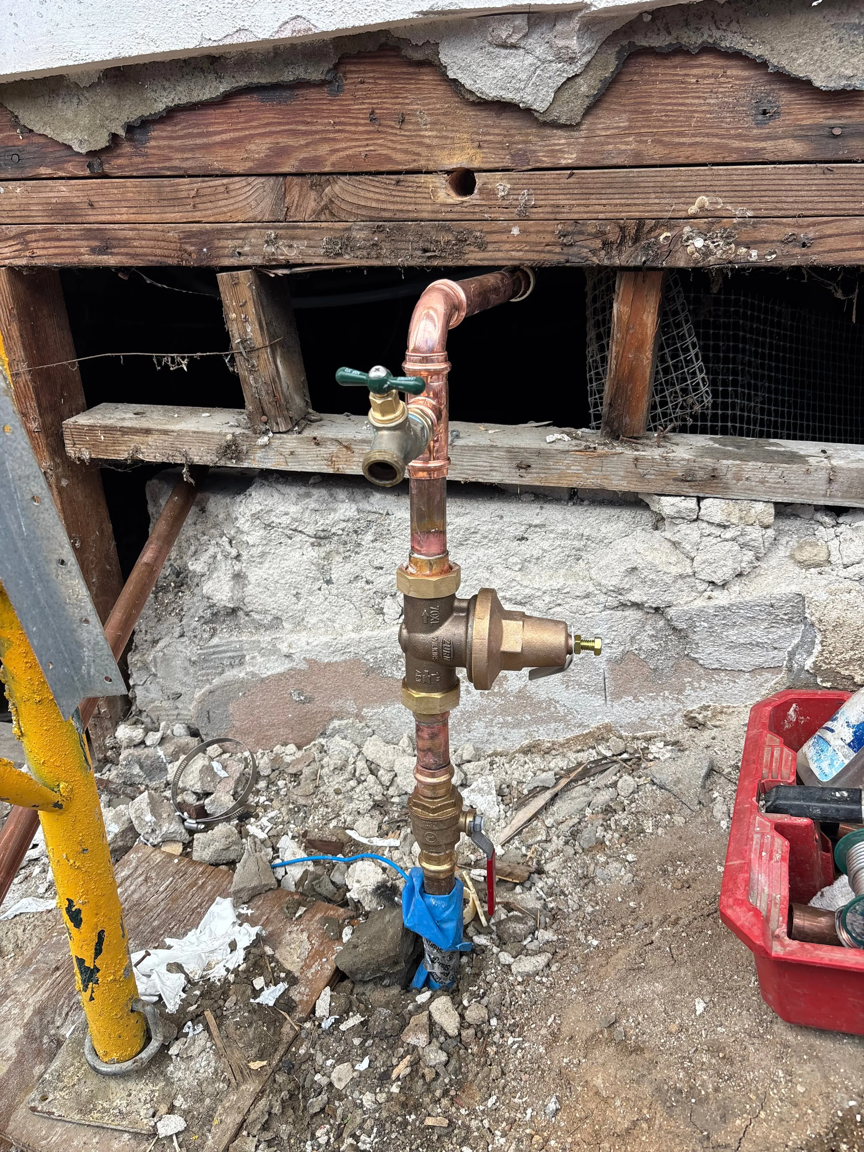 Copper supply with pressure-reducing valve and hose bib rough-in at a remodel foundation