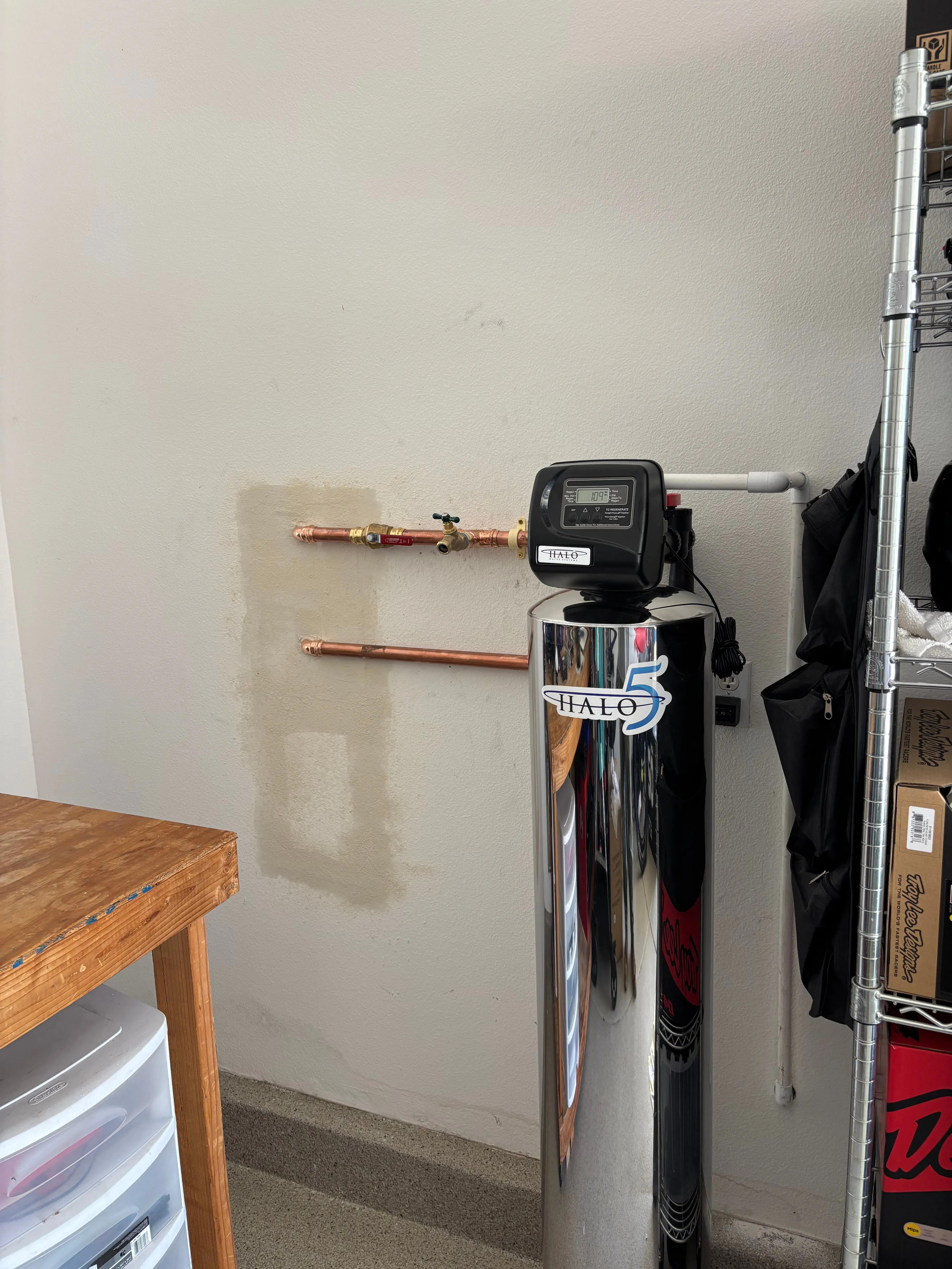 HALO 5 chrome filtration tank with copper supply and hose bib on a garage wall
